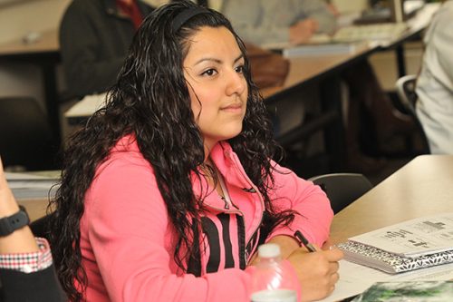 Student smiling and watching instructor in classroom