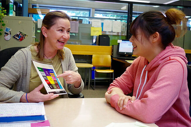 An instructor looking at flashcards with an ESOL student