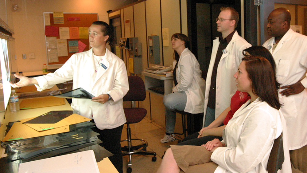 alt="Students and an instructor looking at MRI scans"