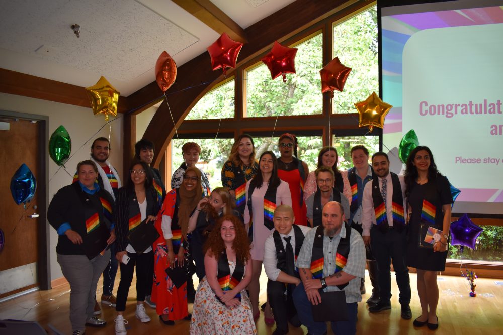 Students at a QRC event with rainbow balloons and sashes